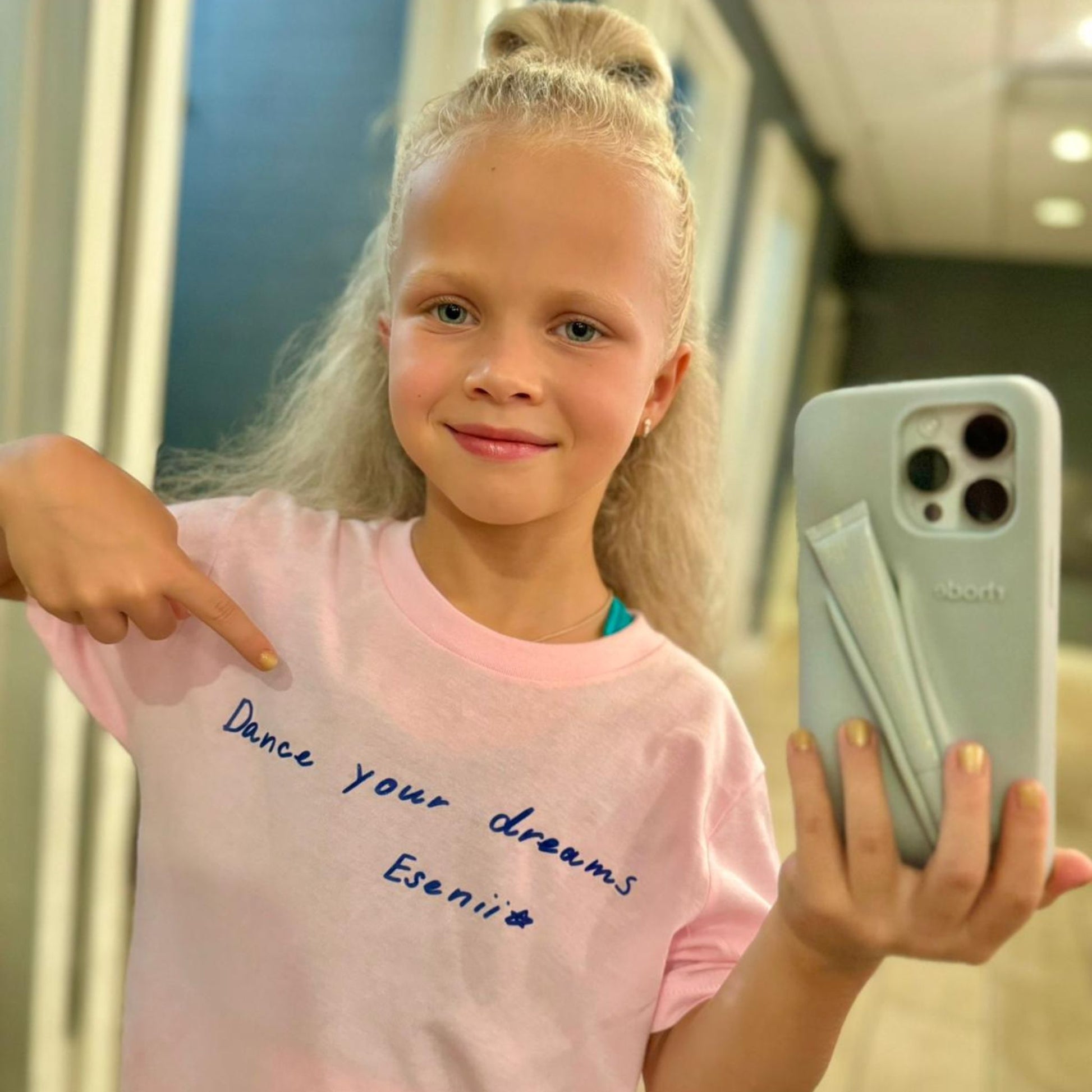 Eseniia wearing Dance Your Dreams T-Shirt in pink, reflection reveals the hidden motivational message