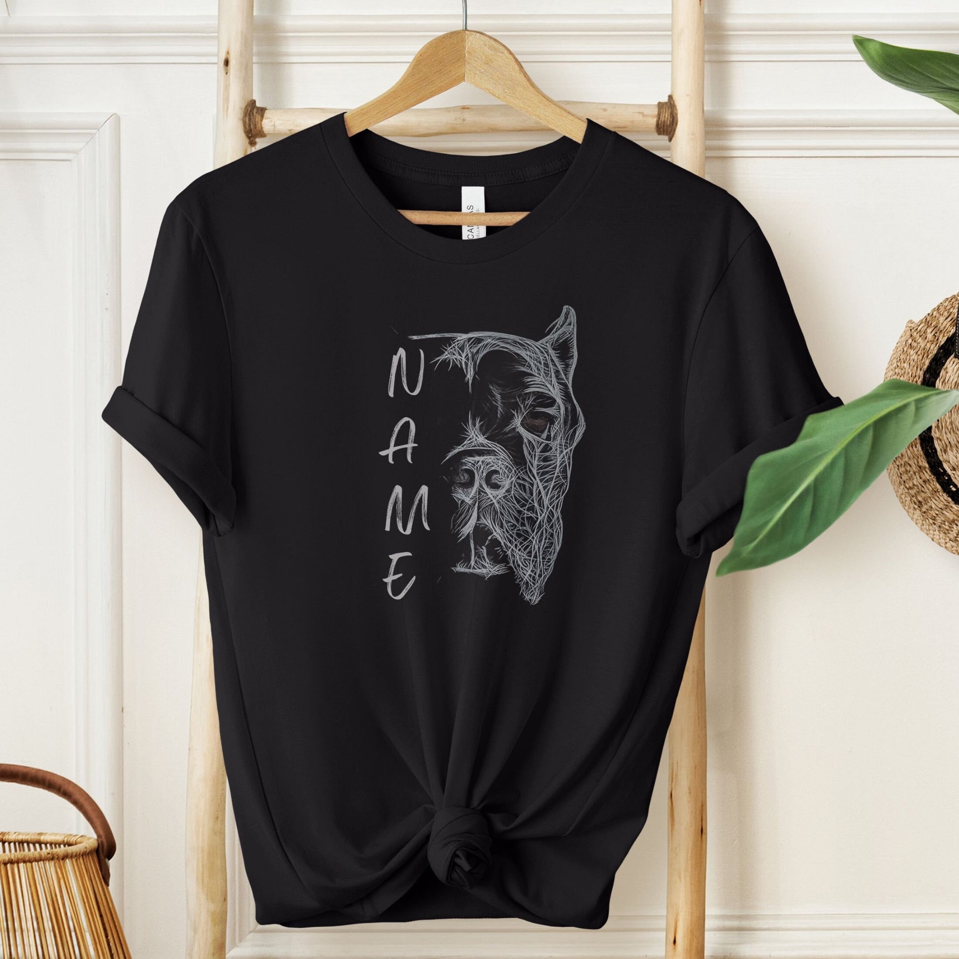 Black unisex tshirt with hand-drawn personalized Cane Corso design with cropped ears hanging on a hook