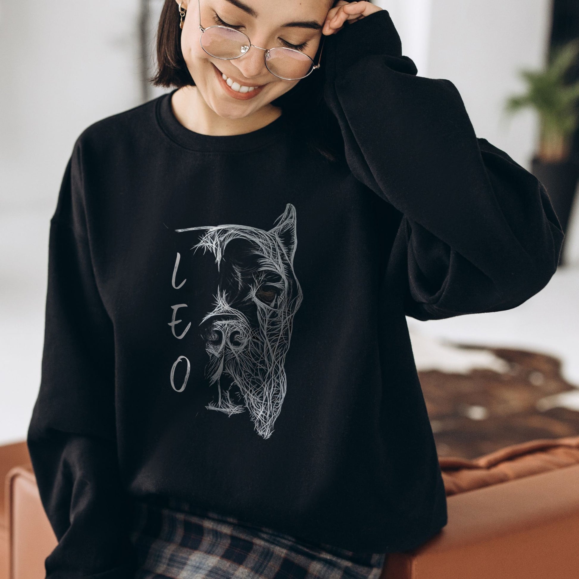 Woman wearing a black unisex sweatshirt featuring a hand-drawn personalized Cane Corso with cropped ears