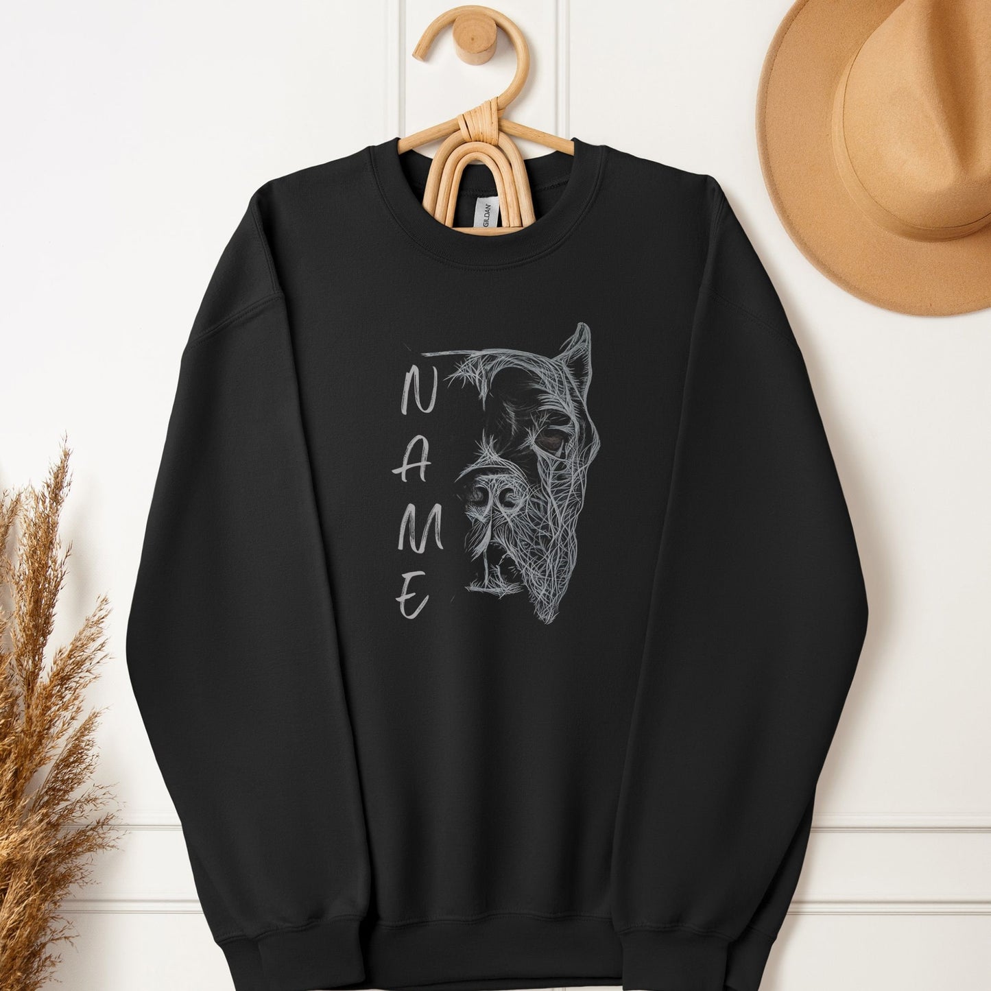 Black unisex sweatshirt with hand-drawn personalized Cane Corso design with cropped ears hanging on a hook